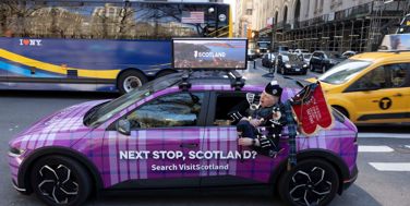 Image of Tattoo Bagpiper in a Visit Scotland car during Tartan Week in NYC