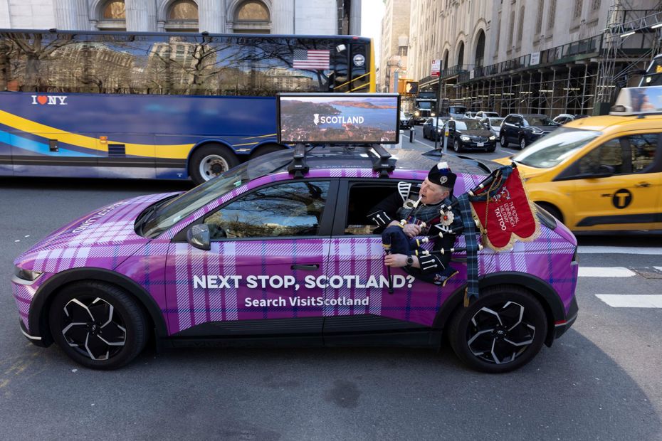 Image of Tattoo Bagpiper in a Visit Scotland car during Tartan Week in NYC